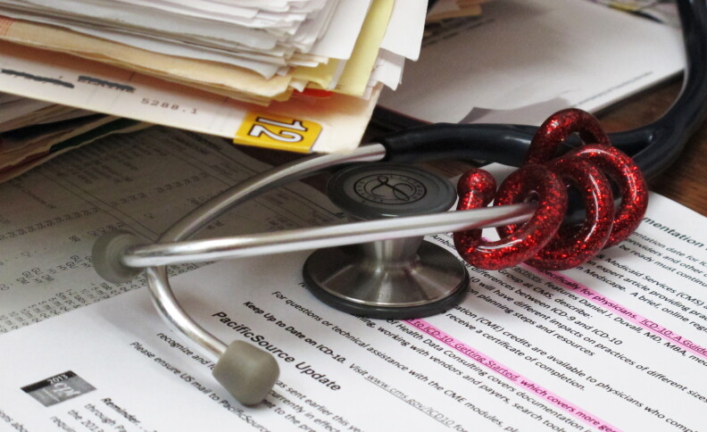 A stethoscope sits next to medical charts.