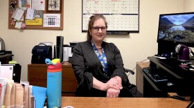 Suzanne Alexander sits at her desk at the St. Louis Department of Health downtown. She wears glasses and has many colorful items on her desk.