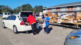 Dozens of volunteers load up cars and carts with fresh groceries and nonperishables at the Second Harvest Food Bank of Central Florida free, mobile food distribution event at the Central Motel in Kissimmee on Tuesday, Dec. 19. 2023. The effort was large but well-coordinated and moved like an assembly line.