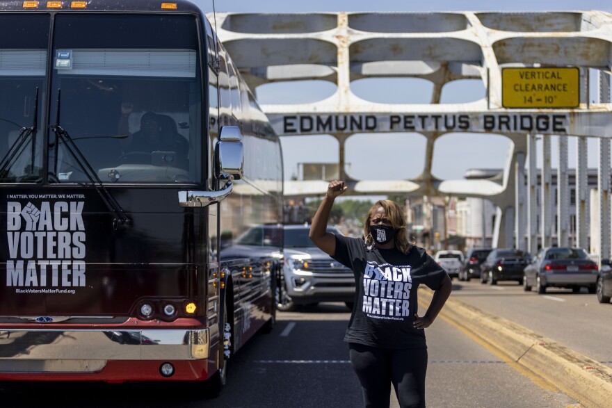 FILE - In this May 8, 2021, file photo, LaTosha Brown, co-founder of Black Voters Matter, stands atop the Edmund Pettus Bridge, a famous civil rights landmark in Selma, Ala. In the nation’s capital on Saturday, Aug. 28, 2021, multiracial coalitions of civil, human and labor rights leaders including Brown's group, are convening rallies and marches to urge passage of federal voter protections that have been eroded since the Voting Rights Act of 1965. (AP Photo/Vasha Hunt, File)