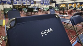 FILE photo - A portable cot, with the Federal Emergency Management Agency logo FEMA printed on the backrest, and other cots line the basketball court at a makeshift medical facility in a gymnasium at Southern New Hampshire University in Manchester, N.H., Tuesday, March 24, 2020.
