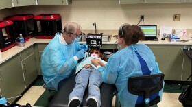 Second grader Estrella receives a dental exam from Dr. Paul Hillis at Roosevelt STEAM Academy in Elkhart.