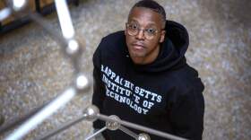 Rapper Lupe Fiasco stands by Antony Gormley's steel sculpture "Chord" at MIT in Cambridge, Mass. (Robin Lubbock/WBUR)