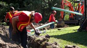 JEA workers digging into the ground outside a home, replacing pipes