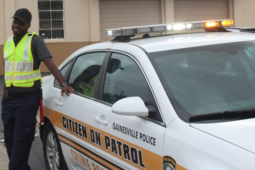 Kyler Hutchinson is a member of GPD's Citizens on Patrol. He stood outside the meeting to help people find parking. (Tangela Morris/WUFT News)