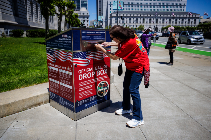Monica Holguin places her ballot at a drop box outside City Hall in San Francisco on May 15, 2026. NPR member stations across California have been tracking these changes to the state’s congressional map, the candidates and the issues in their communities.