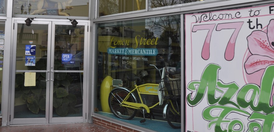 A poster for the upcoming Florida Azalea Festival hangs in the window of Lemon Street Market and Mercantile, owned by Palatka Mayor Robbi Correa.