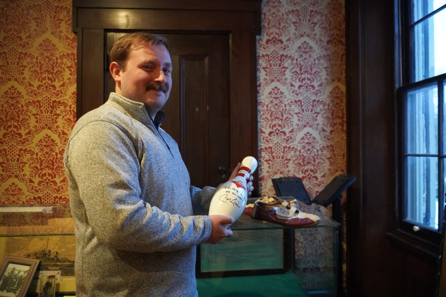 Dustin Smith, the executive director of the Blair County Historical Society, holds a bowling pin signed by former President Barack Obama. Obama visited Pleasant Valley Bowl in Altoona while campaigning in 2008. 
