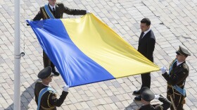 Ukrainian President Volodymyr Zelenskiy, right, attends a ceremony during the National Flag Day celebration at the St. Sophia square in downtown Kyiv, Ukraine, Friday, Aug. 23, 2019. (Ukrainian Presidential Press Office via AP)