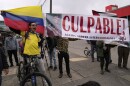 Opponents of former President Alvaro Uribe display a sign reading in Spanish "Guilty" outside the court where a verdict is expected in his trial for witness tampering in Bogota, Colombia, Monday, July 28, 2025.