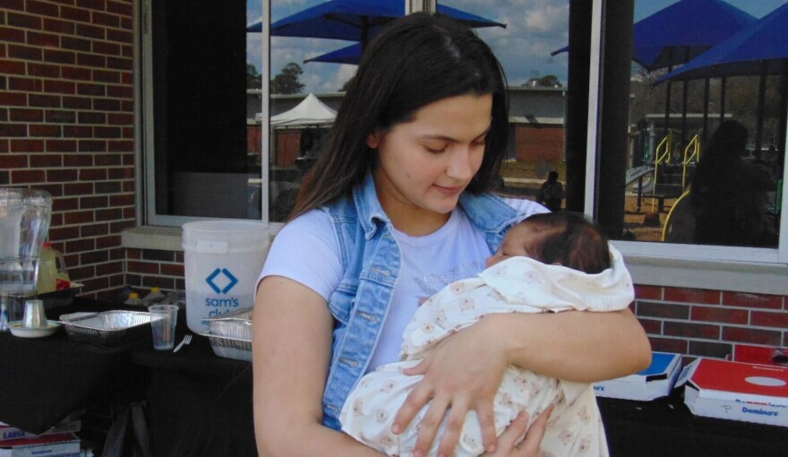 A mother holds her baby during the Womb to World community maternal health event on Saturday, Feb. 21, 2026, in Gainesville, Fla. The event brought families together for health resources, workshops and support. (Annaleis Holz/WUFT)