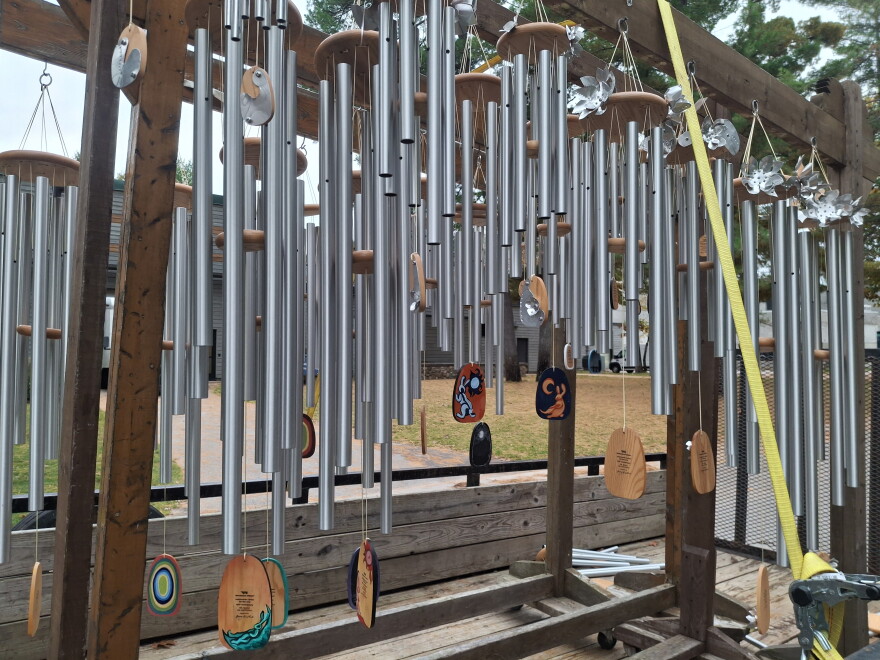 Dozens of wind chimes hang from wooden beams strapped to the bed of a truck.
