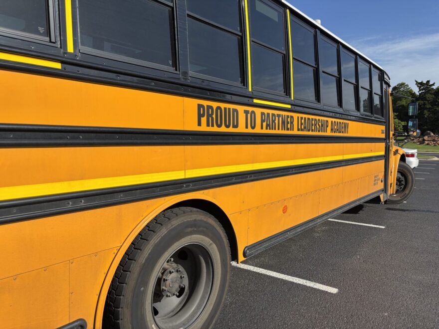 A school bus from Proud to Partner Leadership Academy is parked in front of the Oklahoma History Center in Oklahoma City on April 29 while a termination hearing for the school goes on inside.