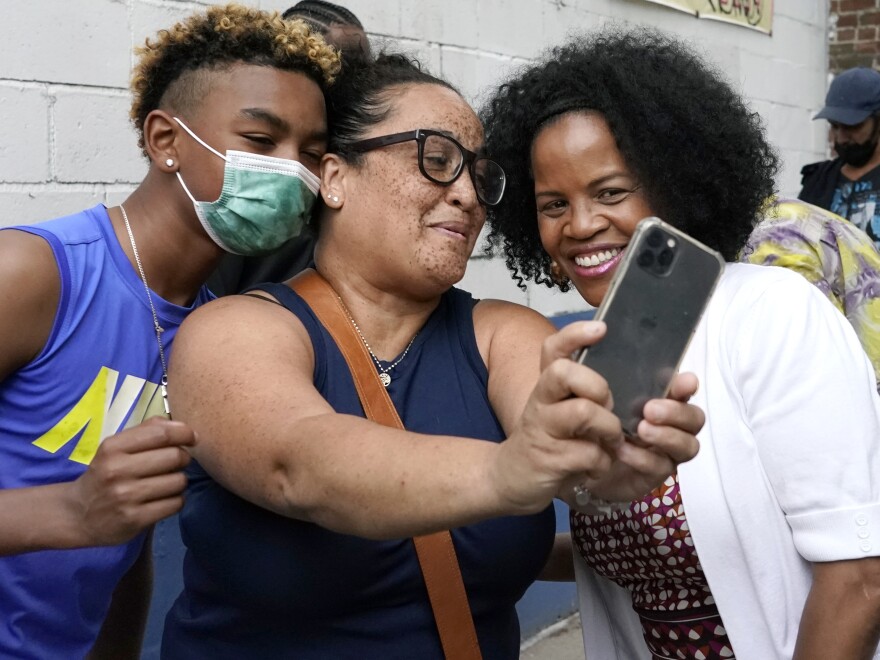 Acting Mayor Kim Janey, right, takes a photo as Bostonians gather together on Friday in Nubian Square. Janey is the first woman and first Black person to serve as mayor of Boston.