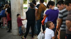 Familias de migrantes recientemente liberadas de la detención federal esperan para abordar un autobús en una estación de autobuses en McAllen, Texas, Estados Unidos, 31 de julio de 2019.