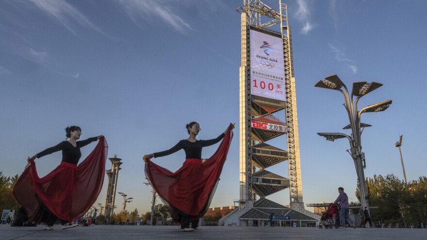 Women practice a dance routine on Oct. 27 in front of a large countdown screen showing 100 days before the opening of the Beijing 2022 Winter Olympics.