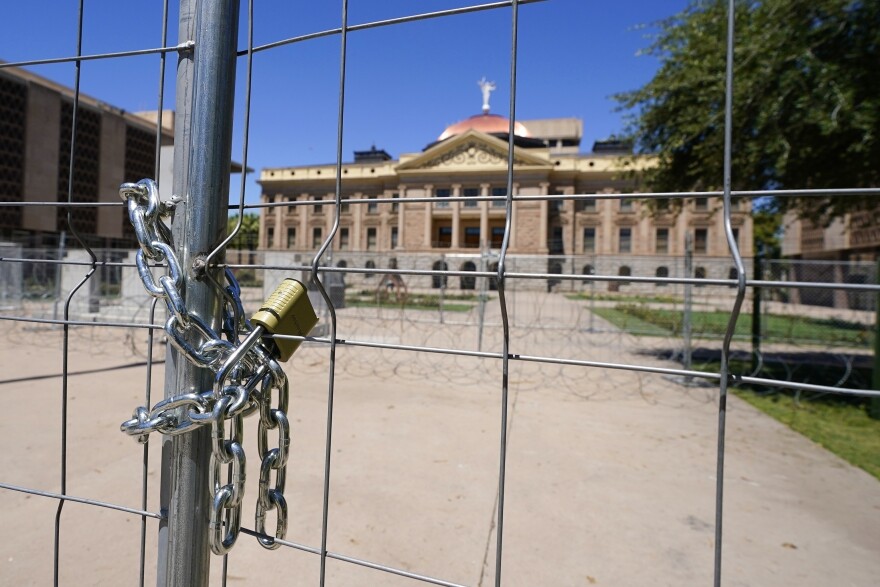 After multiple nights of abortion-rights protests, security fences and barbed wire surround the Arizona Capitol, Monday, June 27, 2022, in Phoenix.