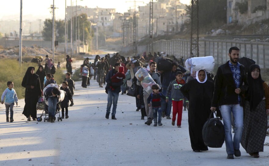 People flee rebel-held eastern neighborhoods of Aleppo on Sunday into the Sheikh Maqsoud area, which is controlled by Kurdish fighters.