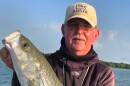 A fisherman showing off a striper catch on Lake Texoma