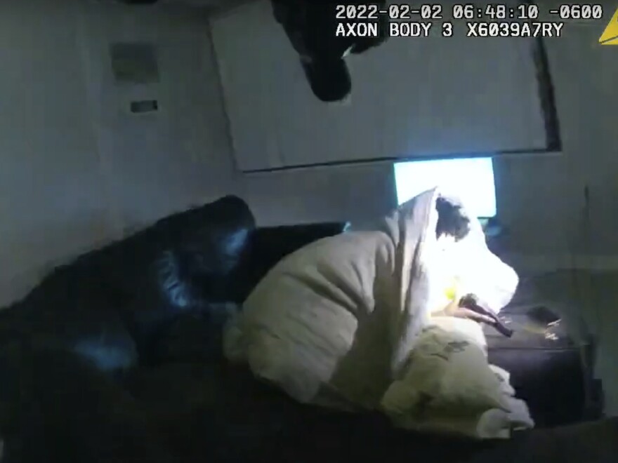An image taken from Minneapolis Police Department body camera video and released by the city of Minneapolis shows Amir Locke, 22, wrapped in a blanket on a couch holding a gun, just before he was fatally shot by Minneapolis police as they were executing a search warrant.