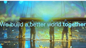 Screengrab from Micron's promotional video of several people in cleanroom suits holding up a piece of electronics, standing on an image of a circuit board