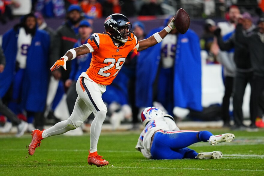 Denver Broncos cornerback Ja'quan McMillian (29) reacts after intercepting a pass intended for Buffalo Bills wide receiver Brandin Cooks (18) during overtime of an NFL divisional round playoff football game, Saturday, Jan. 17, 2026, in Denver.