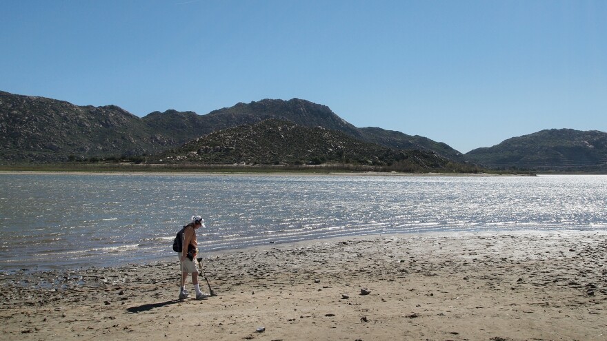 Marty Gabriel, a retired truck driver, passes his metal detector over the exposed sand at California's Lake Perris. Gabriel has been visiting the lake for 25 years. "We definitely need rain," he says.