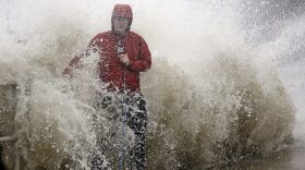 A news reporter doing a stand up near a sea wall in Cedar Key, Fla., is covered by an unexpected wave as Hurricane Hermine nears the Florida coast, Thursday, Sept. 1, 2016. (AP Photo/John Raoux)