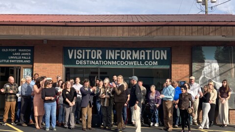 Community members celebrate at a ribbon-cutting outside the new Destination McDowell Visitor Center Thursday, Nov. 20, 2025.