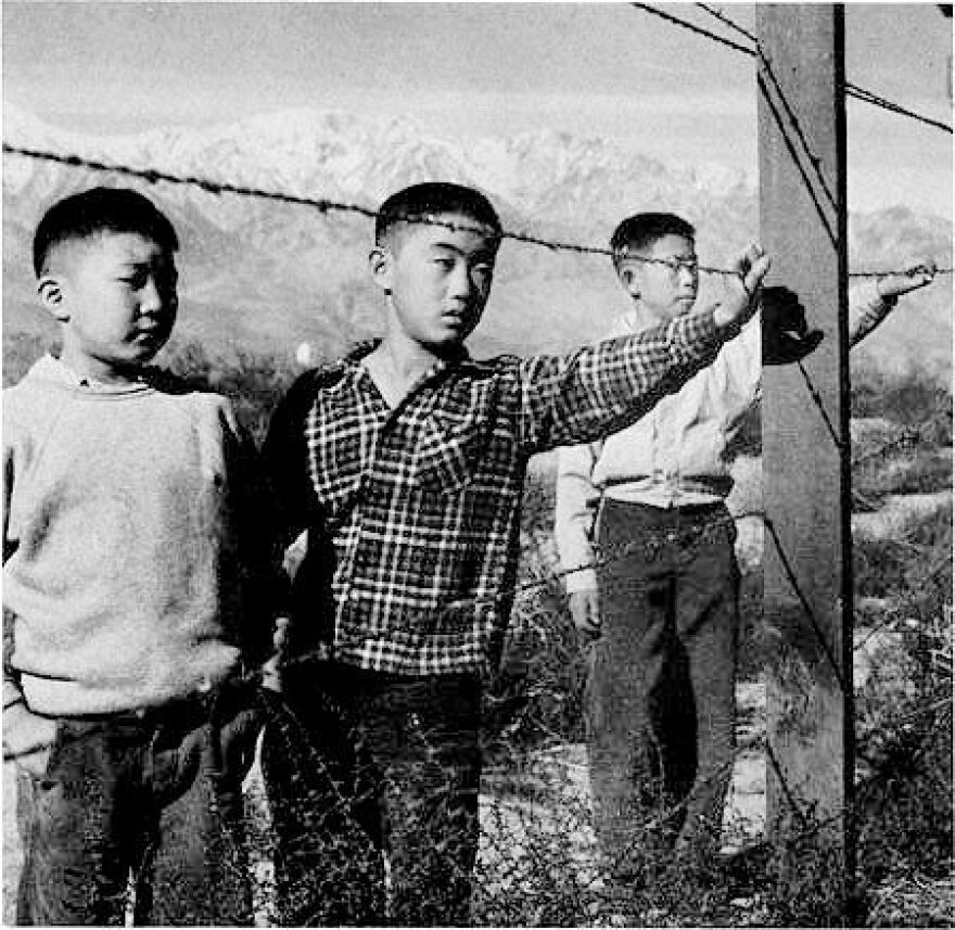 Japanese boys interned at Manzanar look past the fence