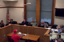 A room filled with people speaking to a podium.