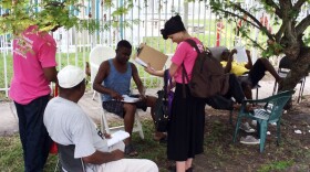 Lenroy Watt (left) and Blair Brown, both Planned Parenthood canvassers, share information about mosquito control, family planning and the risks of Zika in their informal neighborhood meetings.