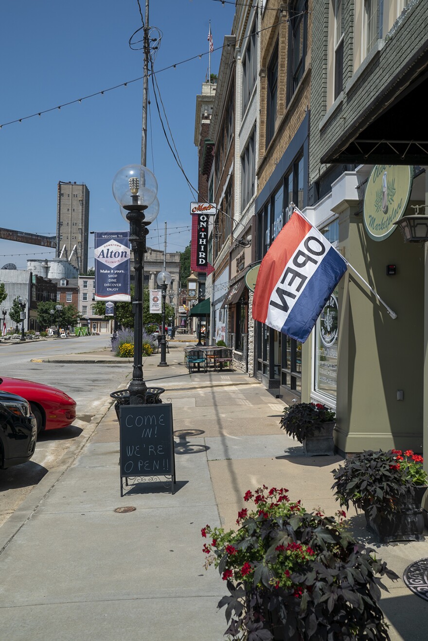 Businesses in downtown Alton display signs and flags indicating they're open on July 2, 2019. Major flooding forced many of them to close for nearly two months in May and June.