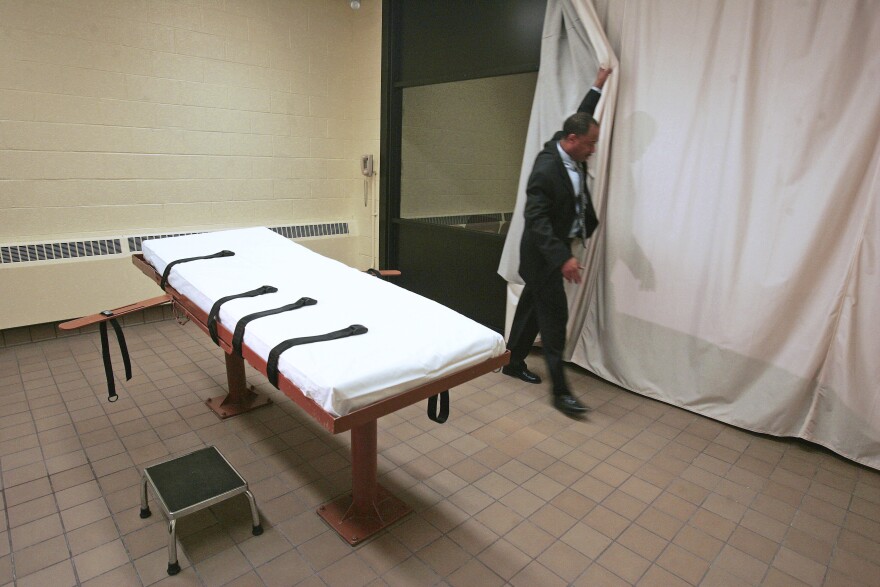 In this November 2005 file photo, Larry Greene, public information director of the Southern Ohio Correctional Facility, demonstrates how a curtain is pulled between the death chamber and witness room at the prison in Lucasville, Ohio.