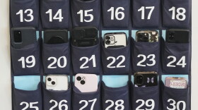 FILE - A phone holder hangs in a classroom in Utah.