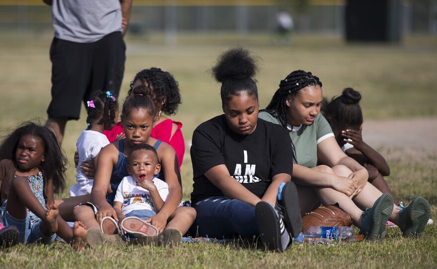 Family and friends, including Tah-Jae Franklyn, 16, in black, listen to a speaker during the one year remembrance, reflection and healing event on the anniversary of the death of Charleena Lyles on Monday, June 18, 2018, at Magnuson Park in Seattle.