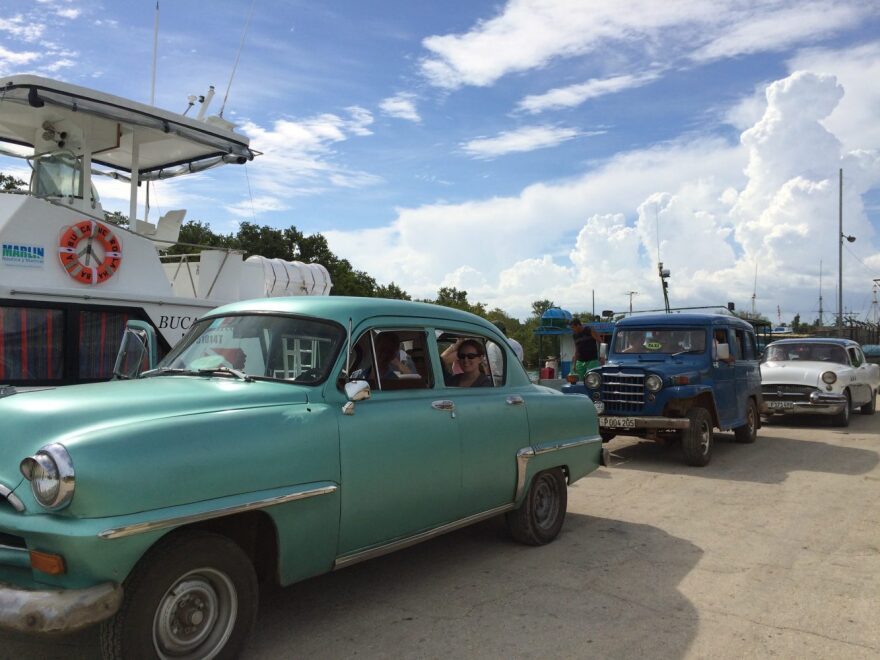 A group of UF students studying abroad in Cuba this summer. After returning from the Isle of Youth, their bus back to Havana was no where to be found, so the professors arranged a caravan of classic cars to drive the students back to the capital. "Couldn’t have planned that one better and we’ll be taking the cars next year instead of the bus," professor Donald Behringer said. Photo courtesy of Donald Behringer.