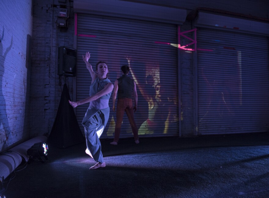 Natalia Ashikhmina and Mark Krieger, with Kristen Sink projected in the background, in Justin Michael Hogan's "35 662618 632814 5"