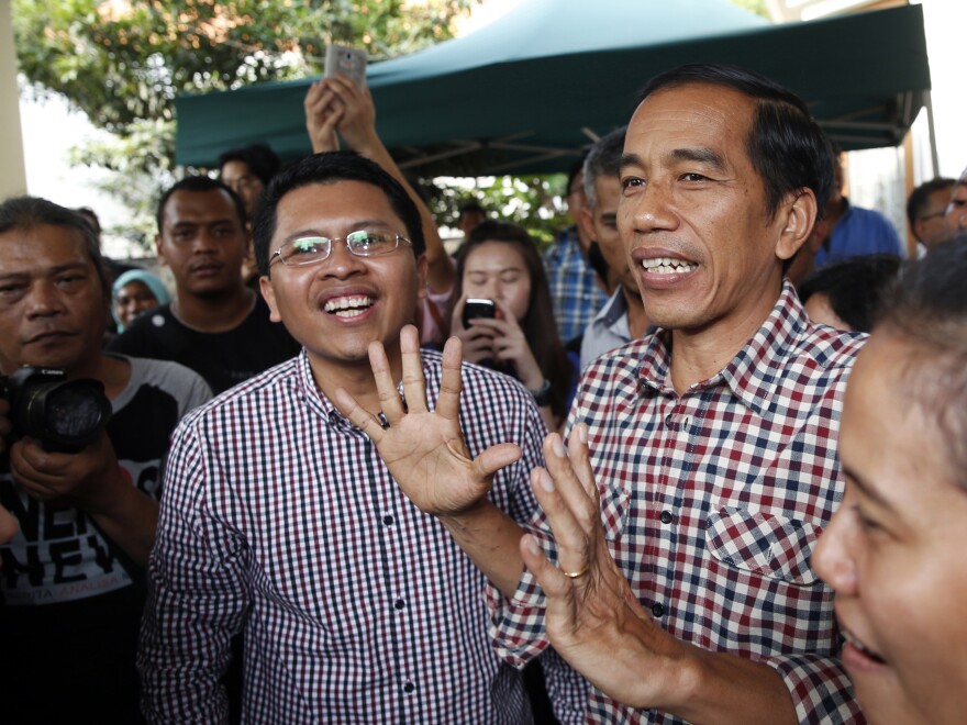 Indonesian presidential candidate Joko "Jokowi" Widodo (center) holds a news conference Thursday in Jakarta. "Quick counts" of the election results give Widodo a narrow lead over his rival.