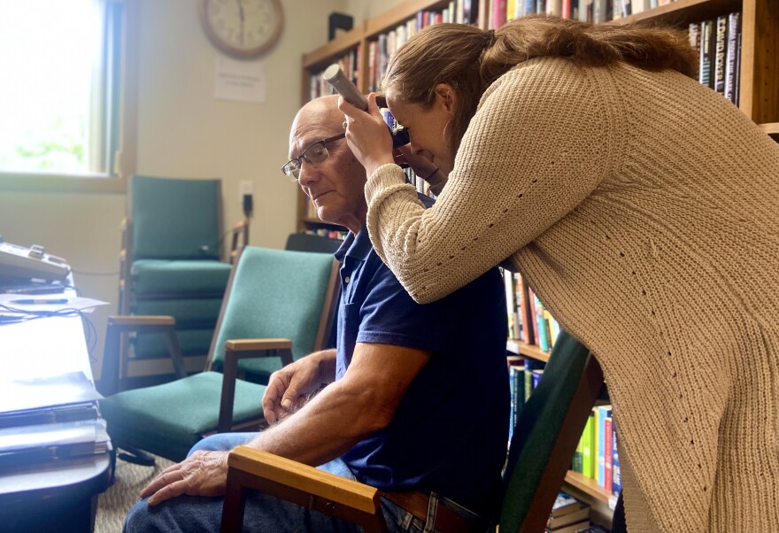  Amanda VanFossen, a hearing aid specialist from Tri-City Hearing, checks John Blazicek's ears before testing his hearing.