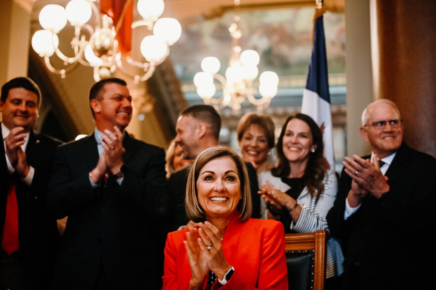 Gov. Kim Reynolds claps after the signing of a 2023 property tax bill.