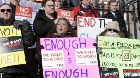 Internal Revenue Service employees display placards during a rally by federal employees and supporters on Jan. 17 in front of the State House in Boston. (Steven Senne/AP)