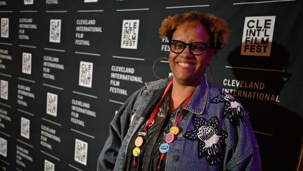 A woman stands smiling