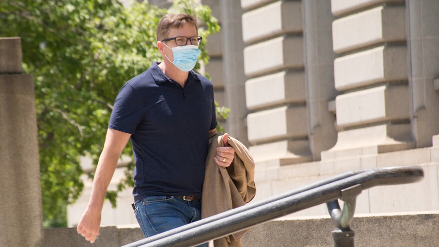 Cleveland City Council President Kevin Kelley, wearing a mask, walks up Cleveland City Hall steps in June. Legislation passed Wednesday requires face masks in most public settings in the city.  [Nick Castele / ideastream]