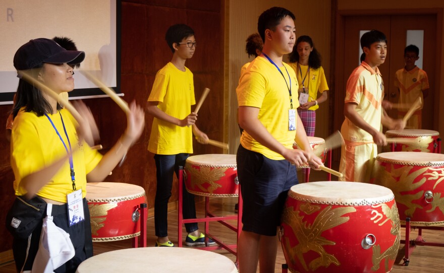 Students from the U.S. and Indonesia play drums in a music class in Taishan.