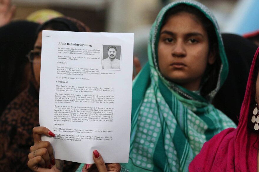An unidentified relative of Aftab Bahadur shows a document with his photo during a news conference in Lahore, Pakistan, on Tuesday.
