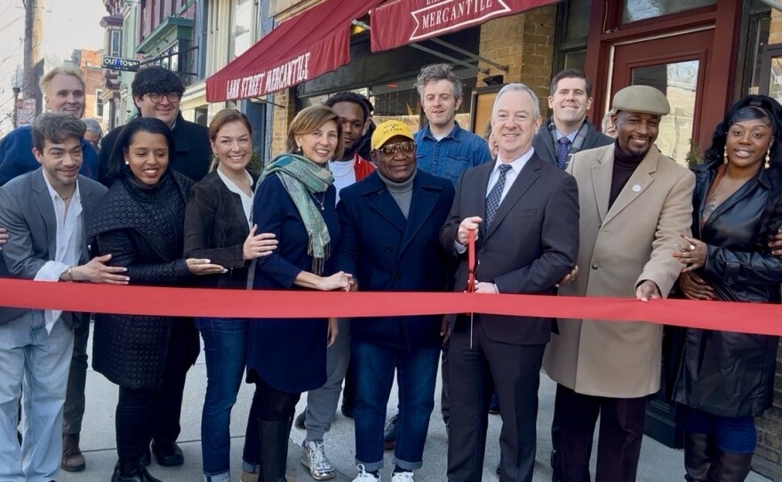 Lark Street Business Improvement District leaders are joined by local lawmakers and business owners to cut a ribbon during a celebration of new businesses on the strip on Wednesday, April 8, 2026.