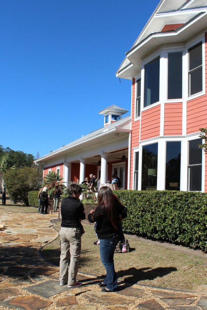 People walk around and talk outside the new Gold Family Campus of K9s for Warriors on Wednesday. (Tangela Morris/WUFT News)