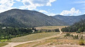 The view looking south from atop the 'Hecla Heap,' a pile of mining tailings left by the most recent mining period, which ended in the mid-1990s. Perpetua plans to remove and reprocess the tailings to extract remaining gold, and create a new mining area here called the 'Hangar Flats pit' to mine the hillside above (not pictured but to the right). In the distance is where Perpetua plans its tailings storage, though it will create a lined and buttressed area to prevent contamination. Meadow Creek, also in the picture, will be re-routed.