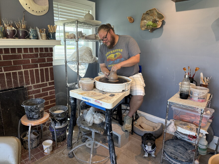 Robert Johnson behind his pottery wheel. Plus his little dog Duncan.